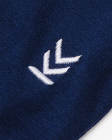 Detail shot of embroidered logo at bottom left hem of Alpine Navy Wild Tee
